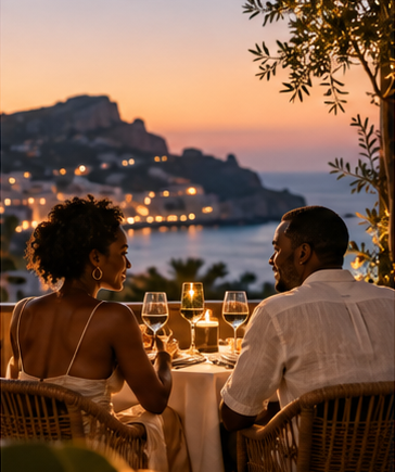 Couple dining outdoors above a sunset coastline