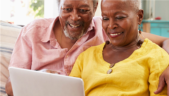 Older Black couple reviewing travel support information on a laptop