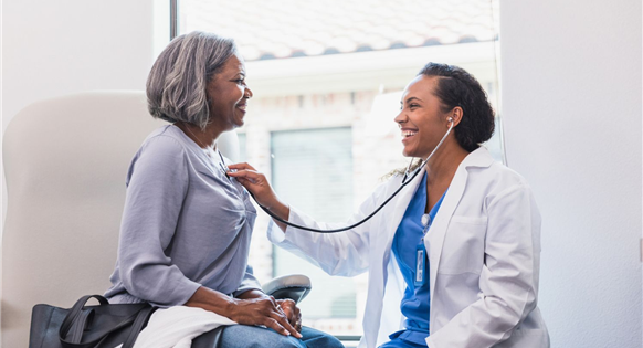 Healthcare professional speaking with an older Black patient during a consultation